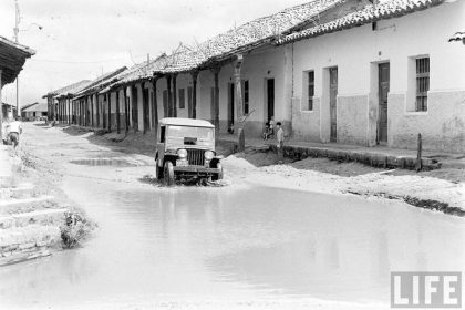         Jeep Willys ingresando al charco de agua formado en la calle Pari esquina Independencia
