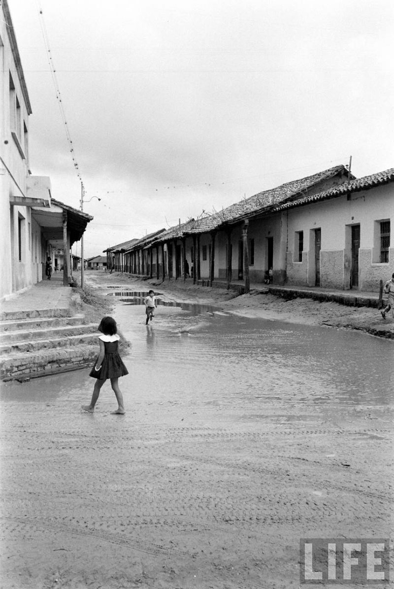         Niños correteando alrededor del charco de agua formado en la calle Pari esquina Independencia
