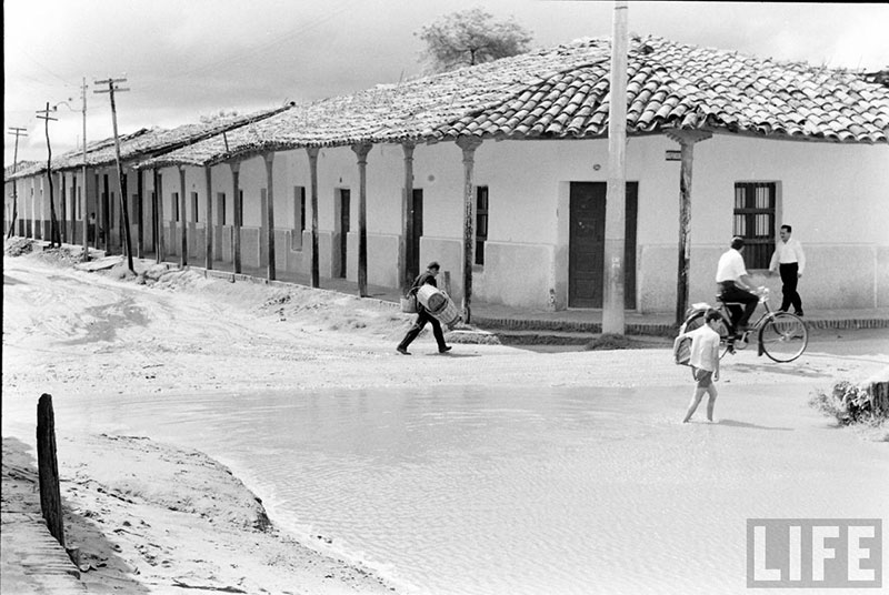         Niño en el charco de agua formado por las lluvias en la calle Pari esquina Independencia – fotografía 2 de 4
