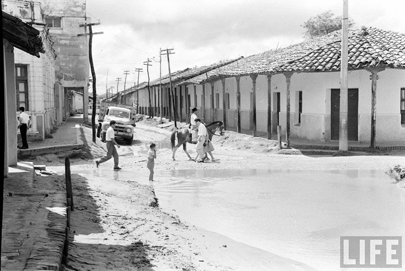         Niño en el charco de agua formado por las lluvias en la calle Pari esquina Independencia – fotografía 3 de 4
